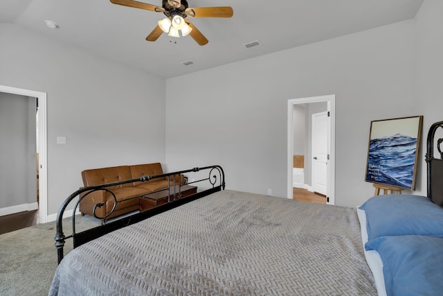 bedroom with lofted ceiling, hardwood / wood-style floors, ceiling fan, and ensuite bathroom