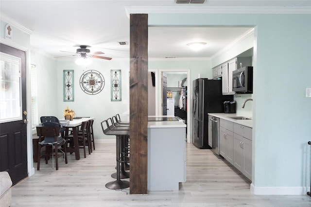 kitchen featuring gray cabinets, ornamental molding, appliances with stainless steel finishes, and sink