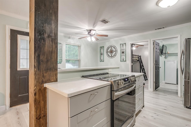 kitchen with crown molding, appliances with stainless steel finishes, ceiling fan, and light hardwood / wood-style floors