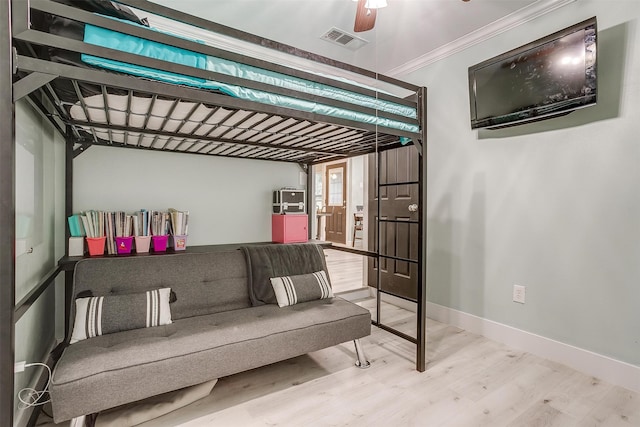 bedroom featuring hardwood / wood-style floors, ceiling fan, and ornamental molding