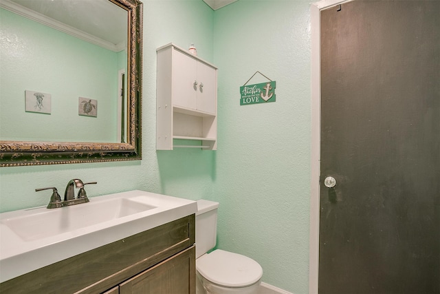 bathroom featuring vanity, crown molding, and toilet