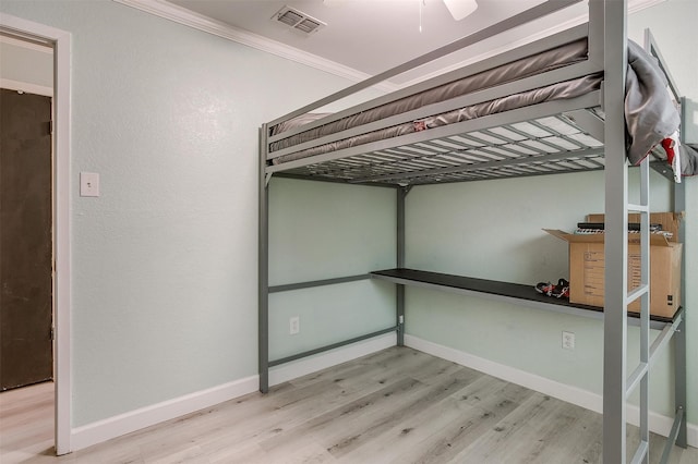 unfurnished bedroom with light hardwood / wood-style flooring, ceiling fan, and ornamental molding