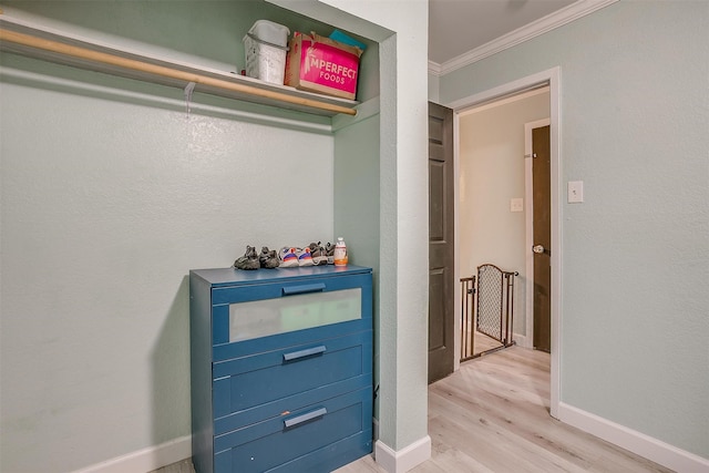 hall with ornamental molding and light hardwood / wood-style floors