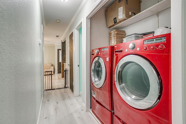 laundry room featuring ornamental molding, separate washer and dryer, and light hardwood / wood-style floors