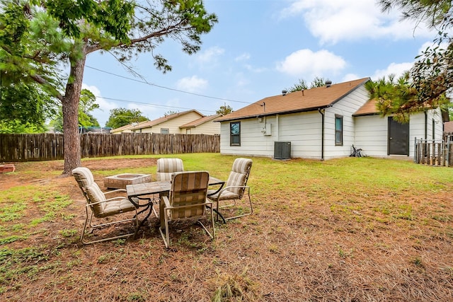 view of yard with a fire pit and central AC