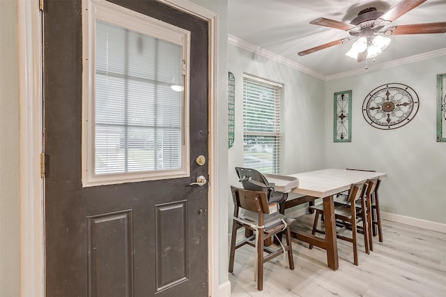 dining room featuring crown molding, a healthy amount of sunlight, ceiling fan, and light wood-type flooring