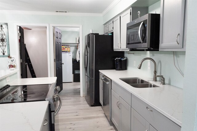 kitchen featuring gray cabinets, sink, light hardwood / wood-style floors, and appliances with stainless steel finishes