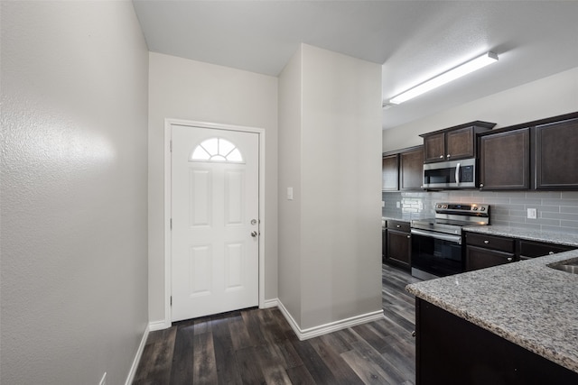 kitchen featuring dark brown cabinetry, dark hardwood / wood-style floors, stainless steel appliances, and tasteful backsplash