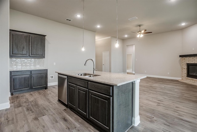 kitchen with dishwasher, a kitchen island with sink, hanging light fixtures, ceiling fan, and sink