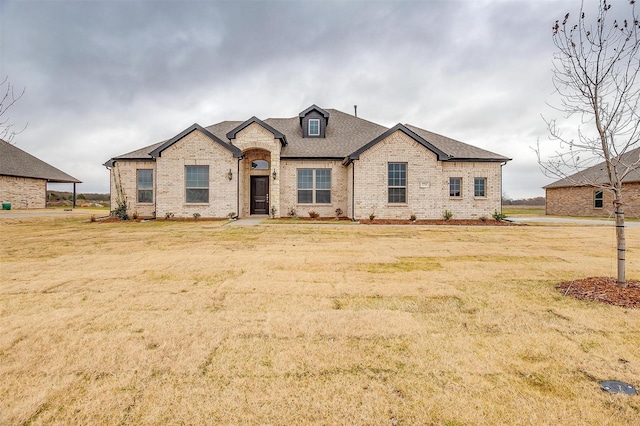 french country inspired facade featuring a front lawn