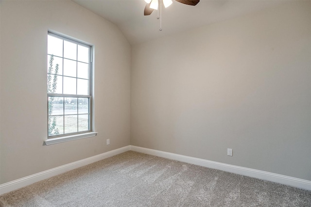 carpeted spare room featuring lofted ceiling and ceiling fan