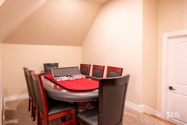 dining room featuring carpet floors and vaulted ceiling