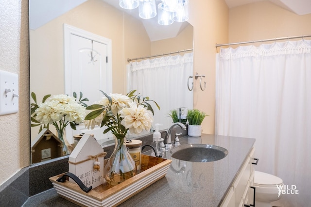 bathroom with vanity, vaulted ceiling, and toilet