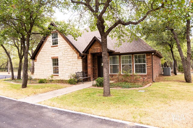 view of front of property with central AC and a front yard