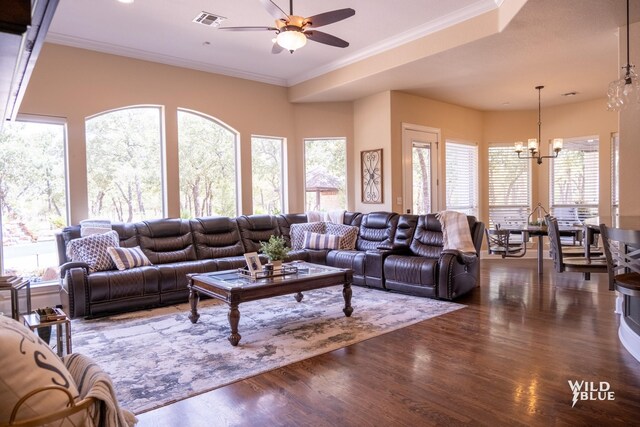 living room with ornamental molding, dark hardwood / wood-style floors, and ceiling fan with notable chandelier