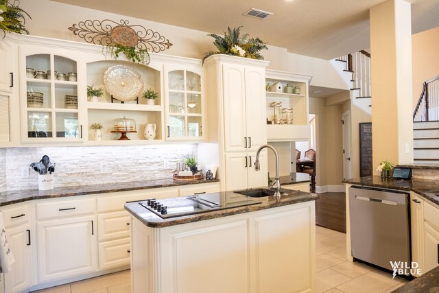 kitchen with white cabinets, dishwasher, sink, and dark stone countertops