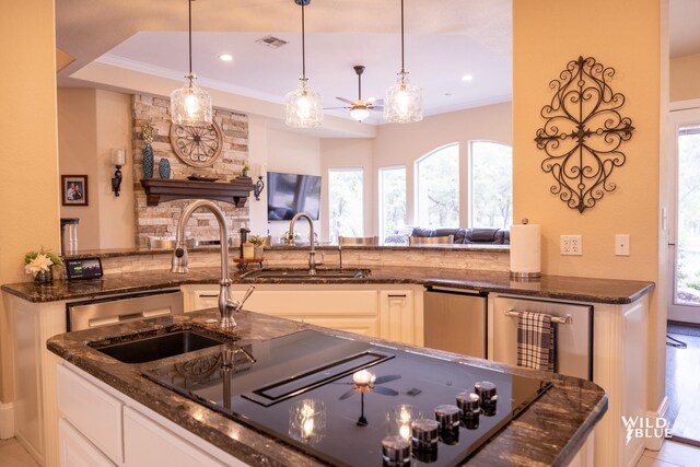 kitchen featuring ornamental molding, decorative light fixtures, and dark stone countertops