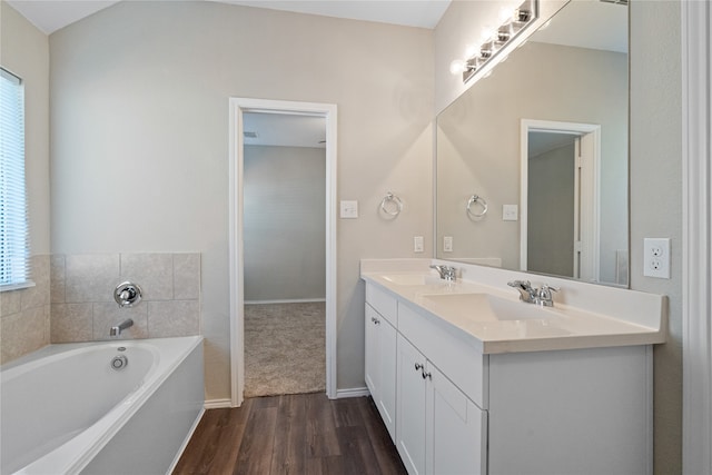 bathroom featuring vanity, a tub to relax in, a healthy amount of sunlight, and hardwood / wood-style flooring