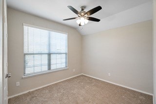 carpeted spare room featuring lofted ceiling and ceiling fan