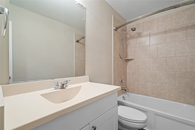 full bathroom featuring vanity, tiled shower / bath combo, and toilet