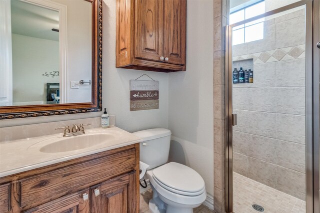 bathroom with a shower with shower door, toilet, and vanity