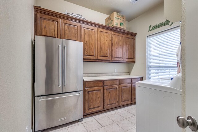 kitchen featuring washer / dryer, stainless steel refrigerator, and light tile patterned flooring