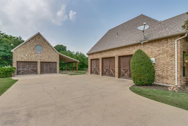 view of side of home with an outdoor structure, a garage, and a carport