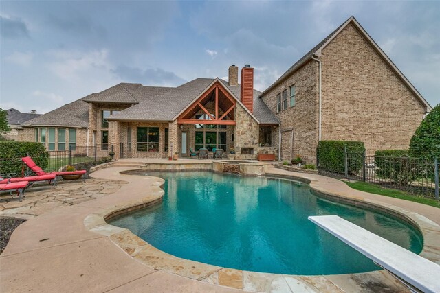 view of swimming pool with a patio area and a diving board