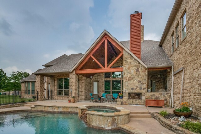 back of property featuring a patio and a swimming pool with hot tub