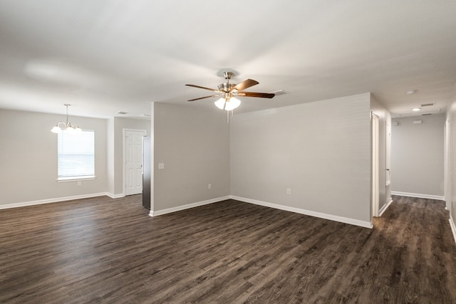 spare room with dark hardwood / wood-style floors and ceiling fan with notable chandelier