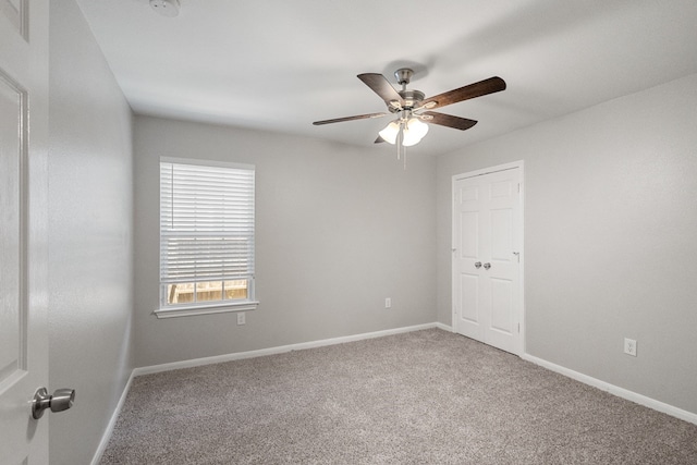 empty room featuring ceiling fan and carpet floors