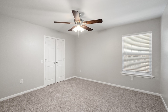 carpeted empty room featuring ceiling fan