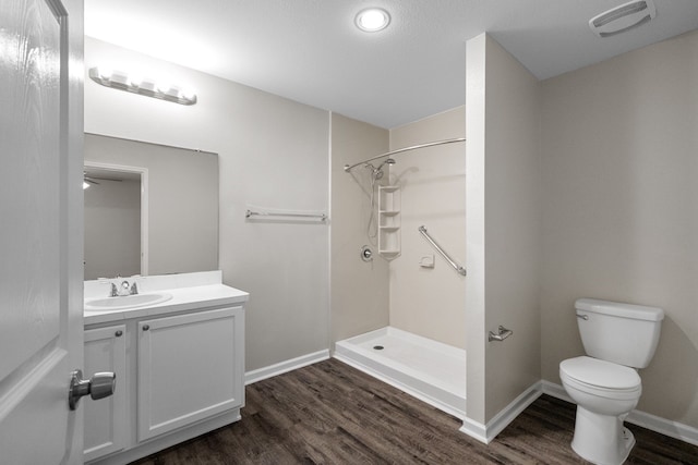 bathroom featuring walk in shower, vanity, hardwood / wood-style flooring, and toilet