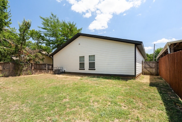 back of house with a lawn and cooling unit