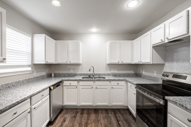 kitchen with stainless steel appliances, sink, dark hardwood / wood-style floors, light stone countertops, and white cabinetry