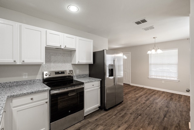 kitchen with white cabinetry, appliances with stainless steel finishes, dark hardwood / wood-style floors, light stone countertops, and an inviting chandelier