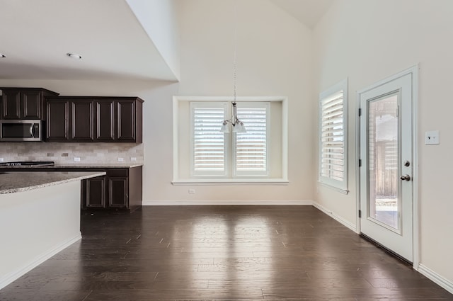 kitchen featuring dark brown cabinetry, lofted ceiling, dark hardwood / wood-style flooring, and tasteful backsplash