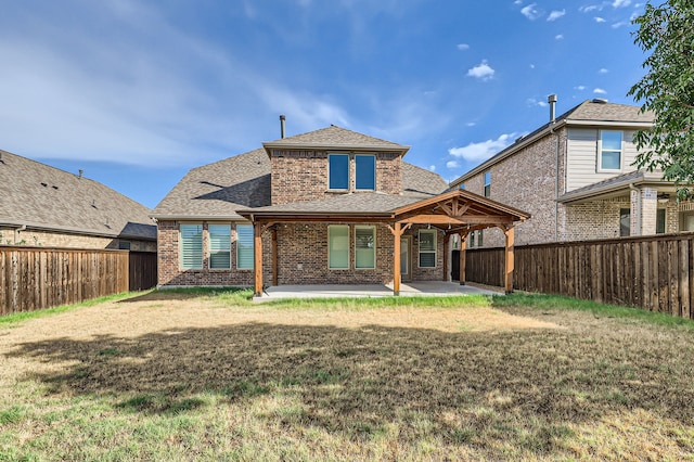 back of property with a yard and a patio area