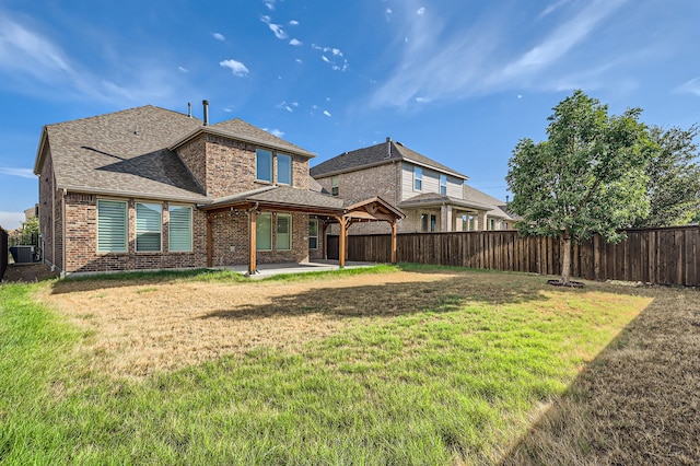 rear view of property with a yard, a patio area, and central AC