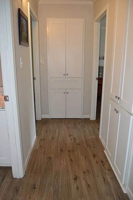 hallway with ornamental molding and dark hardwood / wood-style floors