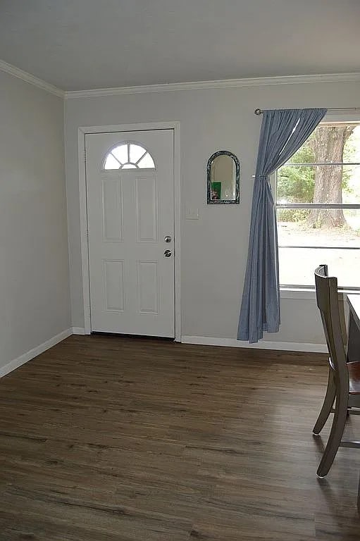 foyer entrance featuring ornamental molding and dark hardwood / wood-style flooring