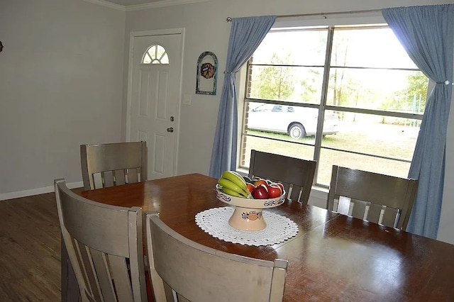 dining room featuring dark wood-type flooring, plenty of natural light, and crown molding