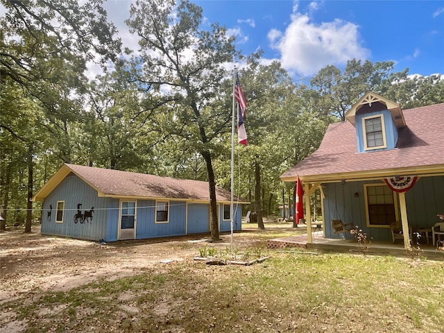 back of house featuring a yard and a porch