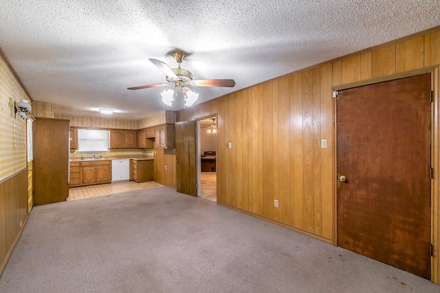 interior space featuring a textured ceiling, sink, ceiling fan, and wooden walls