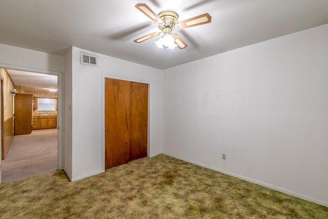 unfurnished bedroom featuring a closet, ceiling fan, and carpet floors