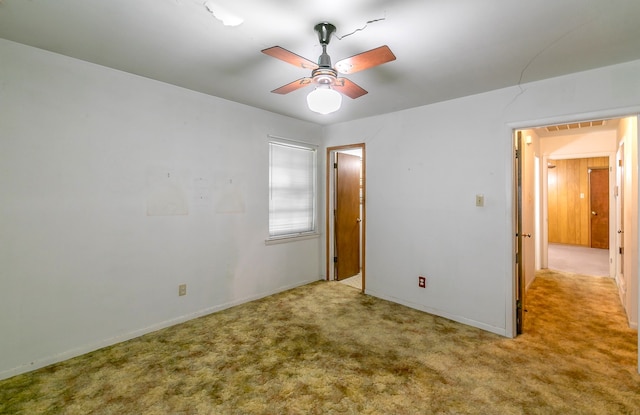 carpeted spare room with ceiling fan