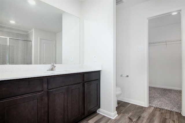 bathroom with toilet, an enclosed shower, hardwood / wood-style flooring, and vanity