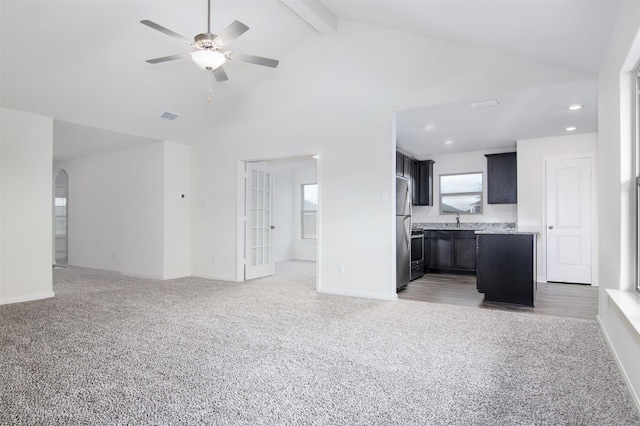 kitchen with high vaulted ceiling, beam ceiling, ceiling fan, and carpet floors