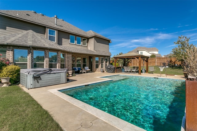 exterior space with a gazebo, a patio area, and a pool with hot tub