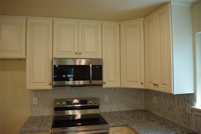 kitchen with white cabinetry, stone counters, and stainless steel appliances